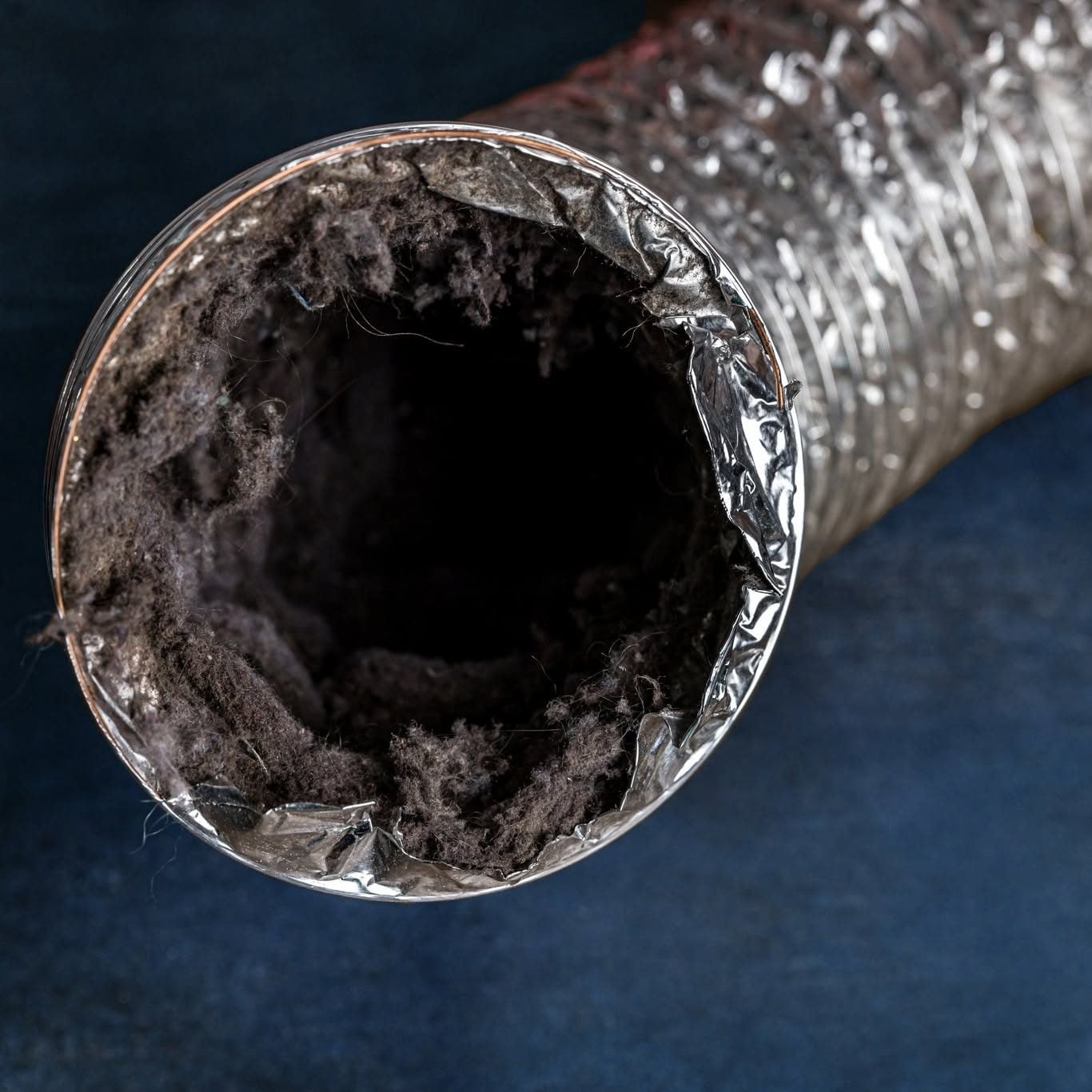 Lint-clogged dryer vent duct before cleaning