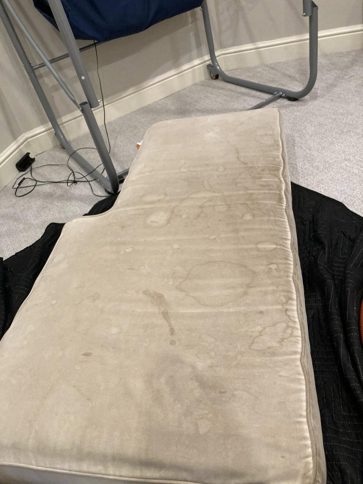 Bench cushion with heavy water-ring staining before professional upholstery cleaning, Shelton CT