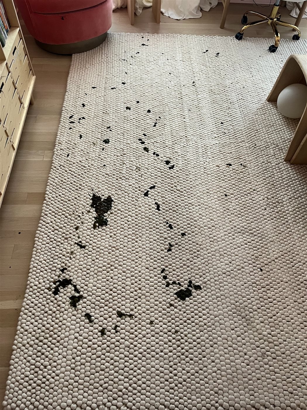 Wool felt-ball area rug with heavy stains before cleaning